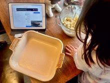 Paco is laying under the table thinking he will surely get something she drops.