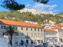 Along the west side of the harbor; you can see the fortress on the hill