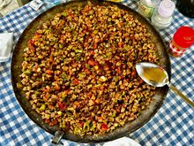 Saçtava - cubed lamb, tomatoes, and peppers cooked on the fire in a paella-style pan