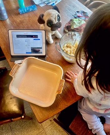Paco is laying under the table thinking he will surely get something she drops.
