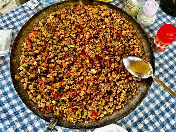 Saçtava - cubed lamb, tomatoes, and peppers cooked on the fire in a paella-style pan