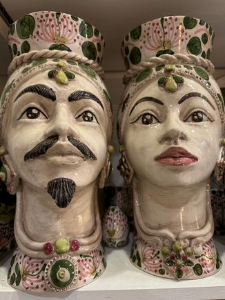 Testa di Moro.....if you saw THE WHITE LOTUS you know the this love story of a male Moor with a local lady.   Particularly popular in Palermo which was more influenced by the Moors than the eastern part of the island.   The better example of these ceramics cost well into the hundreds of euro..they come in all colors and sizes and quality of workmanship...I liked the colors in this pair but would think they are in the middle realm of quality..priced at a bit over 300 euro per piece.