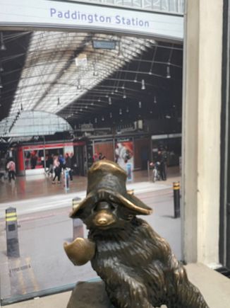 Paddington Bear.  Michael Bond bought a stuffed bear for his wife in 1958 and named it Paddington after the station.  Books and movies followed.  His such a big star now, he wouldn't even speak to me