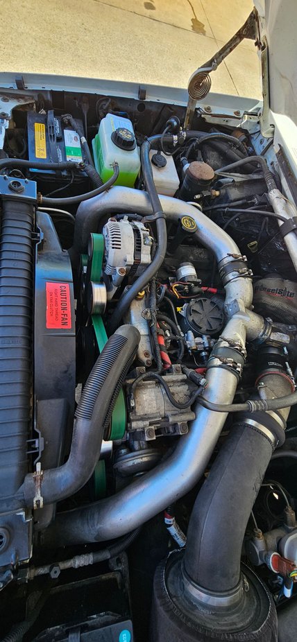 It all fits. Sorry, I dont have more mounting detail pics to share. There is a 6.0 trans cooler in there. Hood latch lever needed to be modded a little. My AC needs to be redone this year, so Ill take pictures when that area gets dismantled. 