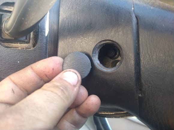 There are two plugs just like this in the back of your steering wheel. Behind them are two 8 mm bolts for your airbag.