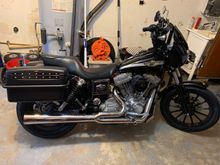 I’ve had this one a long while. I bought this one off my bro, and will NEVER part with it. I did all the mods, has a black Thunderheader now. I ran LeatherPros for a while, that are on the red bike now. I found a set of low mileage T-sport rear shocks and a HD fairing, 8 inch risers and a narrow set of SDC    bars. Switched to a set of Villain2Hero FXDP style bags. I have the factory small rear luggage rack that i’m going to powdercoat black that wil look similar to a FXDP radio rack.


 
