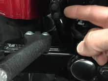 Right side of bike near passenger peg, part of the frame