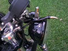 The head light bracket is 3/8" stainless rod forged and welded. It has the ball and socket to match the light and adjust the same as the stock bracket.