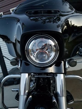 I put one from eagle lights in my streetglide, 6k color temp, i believe Harley daymaker is 5k.  During the day I run high beam and get flashed by cars because its so bright, I'm good with that because thats means they see me!  Both beams stay on when on high.  At night this light is crazy bright and the path is very wide into the trees on the side of the road.