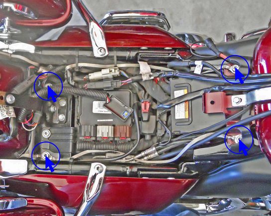 The two Ground Wires that come from the bottom of the Tour Pack attach to the bolts circled in blue on the left. The remaining two Ground Wires run from the bolts circled on the left to those circled on the right.