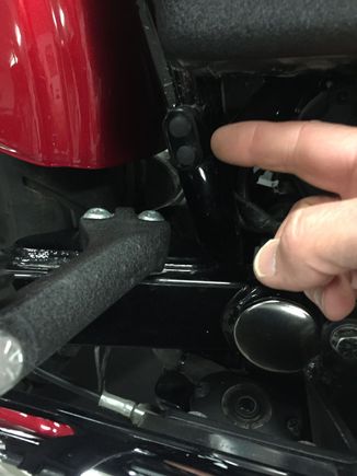 Right side of bike near passenger peg, part of the frame