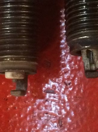 Comparing the two sparkplugs, you can see the insulator has fallen down and a shard broken off.