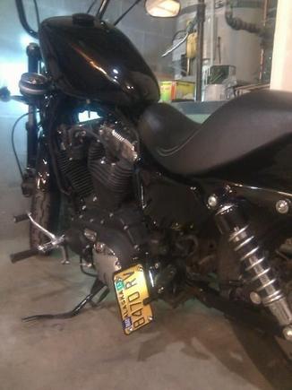 Hacked off my stock license bracket and fabricated a mount to attach it to my passenger peg down low on the bike.