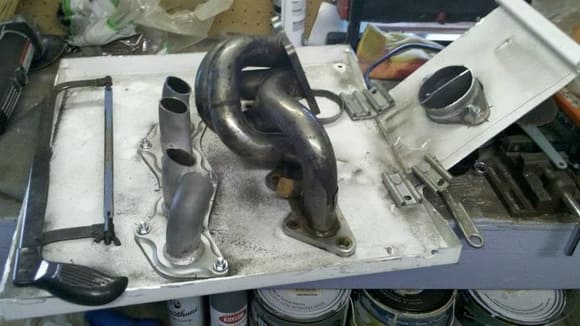 the jig with the center of the dc sports headers cut out, and the megan evo8 twin scroll manifold in the center