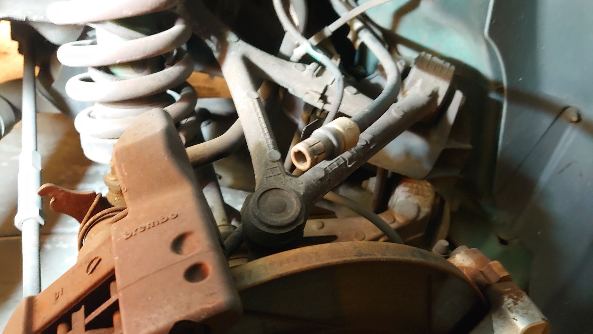 RH parkbrake sheath which cable runs through. Shown unclipped from the small Brembo parkbrake caliper. Snapped end fell off here so no cable visible in photo.
