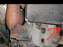 From your perspective, that arrow is pointing towards the passenger side a T25 or T30 Torx screw. Remove that screw and I believe you just pull down on the gray/silver fiberglass panel. 