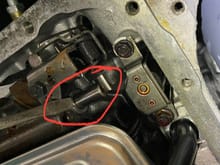 
This is the throttle valve (round shaft in red circle) , viewed with the transmission pan off. This is at the idle position, the lever is putting a small amount of pressure on the throttle valve and depressing it slightly.  At full throttle, the throttle valve is fully depressed and becomes invisible. 