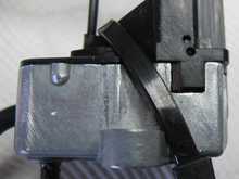 The correct hole to drill is the lower one, that is to hold the cam down