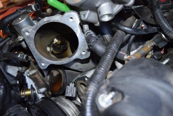Old coolant outlet pipe disengaged from engine.  Throttle body removed for access.
