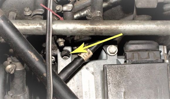 On intake manifold below red arrow