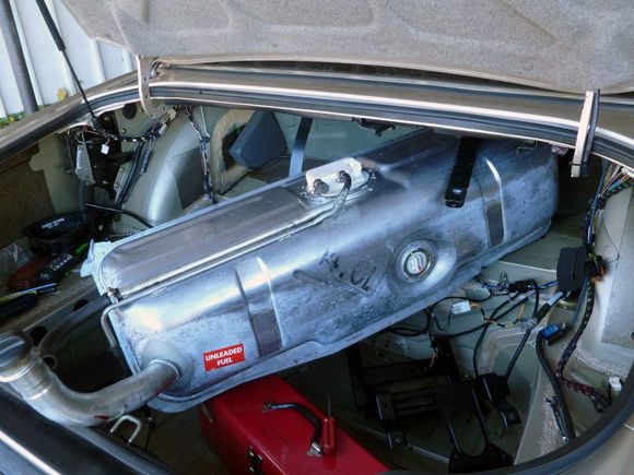 Tank released and supported by toolbox on floor of trunk