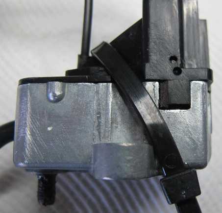 The correct hole to drill is the lower one, that is to hold the cam down