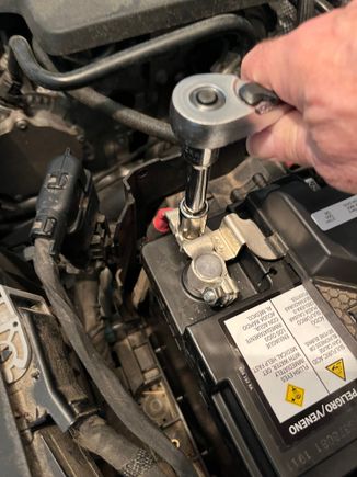 Use a 13mm socket to remove the positive cable from the stud on the positive connector.  There is another 13mm nut connecting the BCM (the black box sitting on top of the battery) to a buss bar that can be removed at this time.