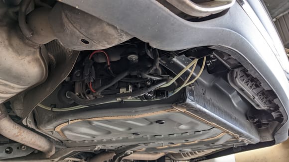 These 3 lines going into the back of the bumper are the height controller solenoid. To the left Compressor neatly tucked in beside spare wheel well once covers are removed. Very easy to access