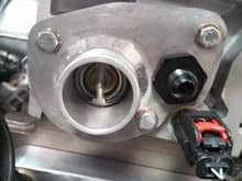 Custom thermostat housing to run GM thermostats, gives you something you can find around any race track
