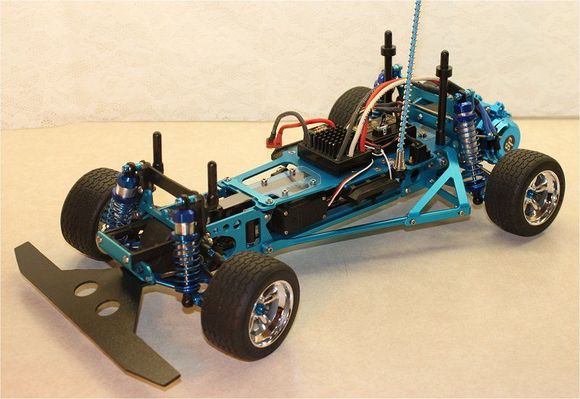 Highly-modified Kyosho Optima chassis re-engineered for onroad driving; narrowed F &amp; R track, custom bumper &amp; front shock tower, narrowed front CVDs, alloy F &amp; R arms, alloy Lazer carriers, belt-drive conversion, 3Racing Lazer shock set, Castle Sidewinder ESC &amp; Speedpassion 17.5T motor.