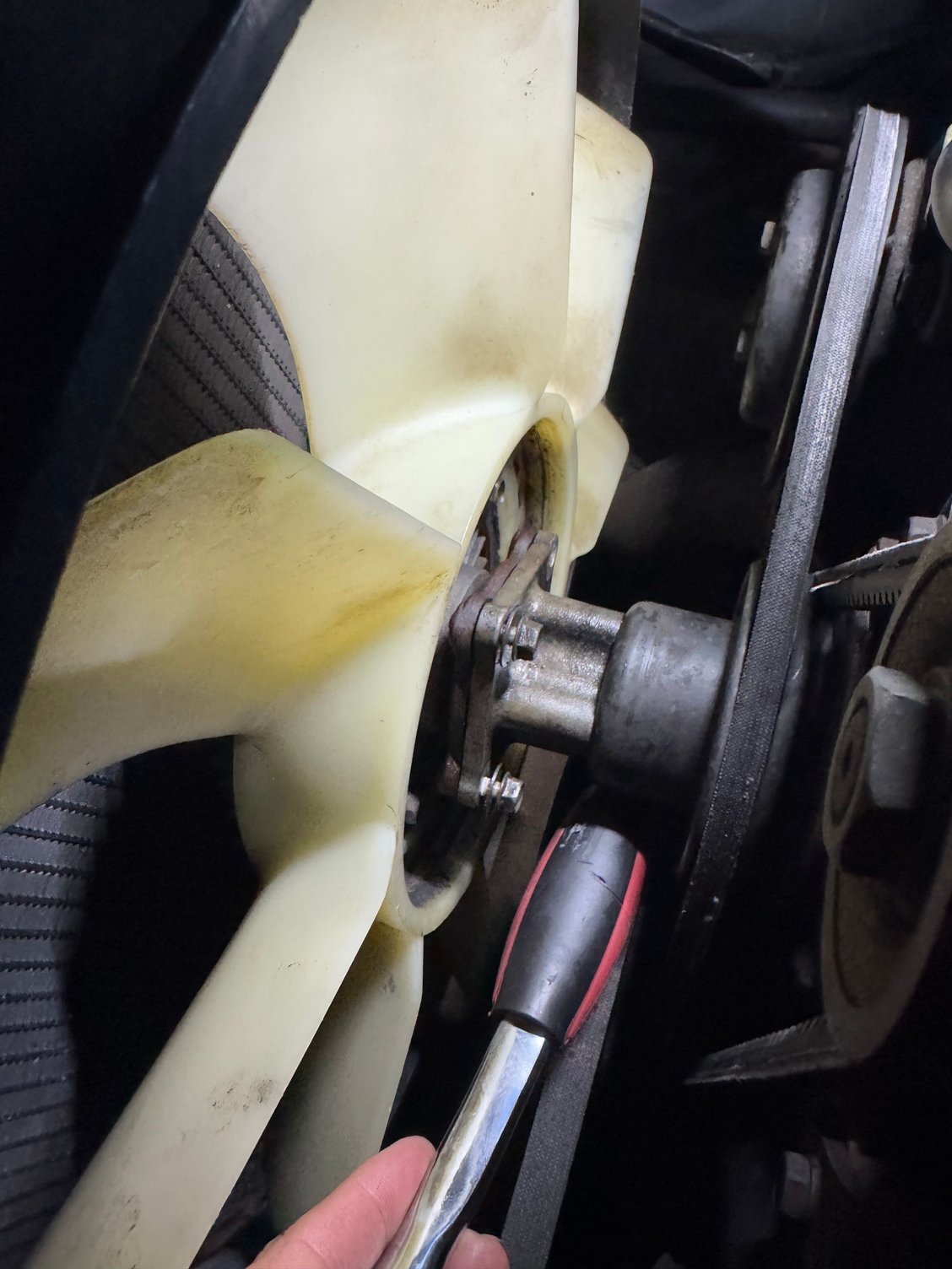 I used a rubber grip wrench to wedge the pulley in place to stop it from moving, while I loosened the bolts.