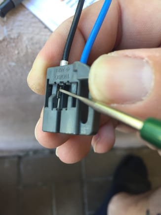 When you underneath the plastic as shown, the pin will come right out by pulling from the wire.