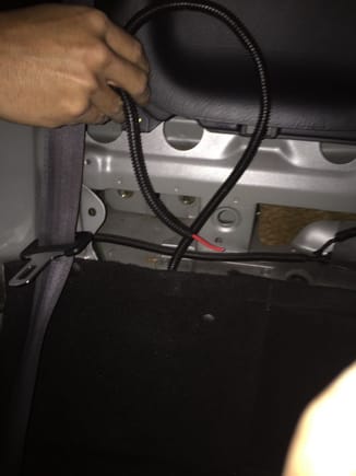 The cable will go into the trunk through behind the passenger seat as shown.