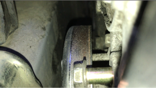 Loose bolt in foreground. Water pump pulley is behind it. Alternator is at upper-right.
