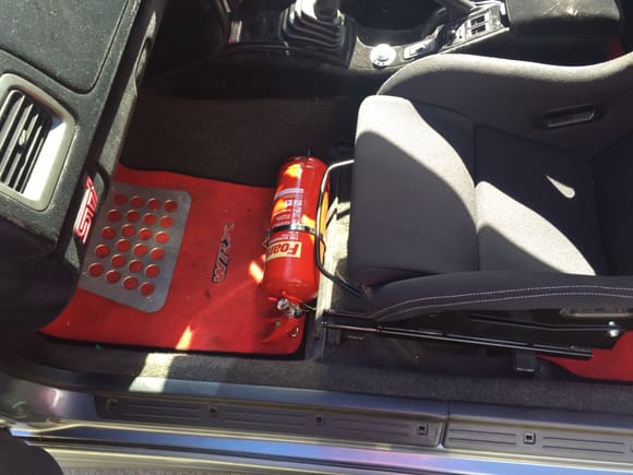 Fire extinguisher in passenger footwell