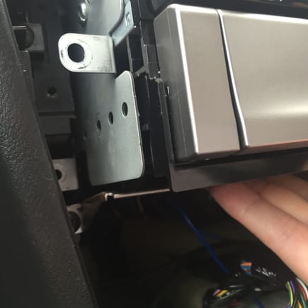 Once you have pushed the stereo and pocket together to stick you can fit back in to the dash. If the brackets will not sit back properly against the screw holes then the lip on the storage pocket may be hitting this bracket. Peel the storage pocket off the head unit and sit the pocket slightly further forward.