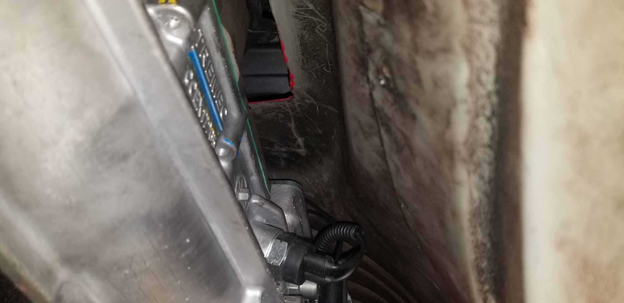 Here, you can kinda see where the front two shifter bolts tuck under the front of the trans tunnel.... looking at it, there MAY be clearance to remove the 10mm bolts with the trans in, but they are pretty dang long... Im certainly going to try to do so before I lower it for my new shifter.  Dang it!