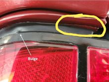 This is paint on the tail light seal. The pic of the "real car" doesnt even show under the edge of the rear quarter....so this area is completely hidden in the pic