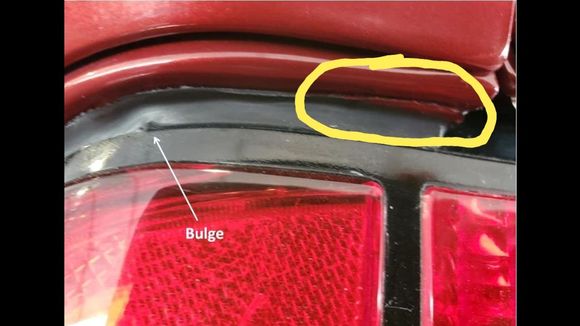 This is paint on the tail light seal. The pic of the "real car" doesnt even show under the edge of the rear quarter....so this area is completely hidden in the pic