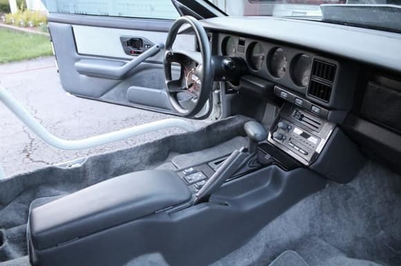 1991 T/A Driver side console and interior, carpet loosened for roll cage install, but all trim parts available for refitting carpet back into place. air bag available or new chrome steering wheel also available.
