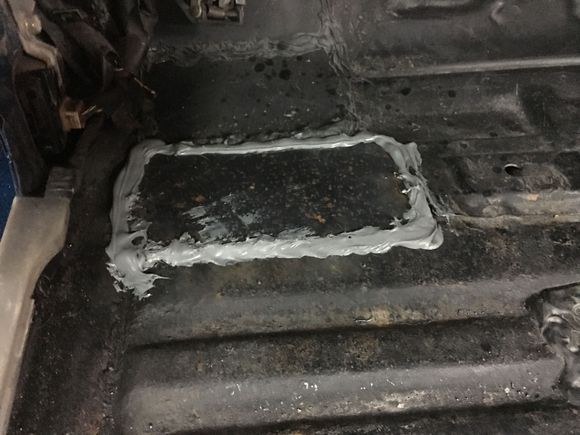 Welded and seam sealed a replacement panel over the body bolt area that had previously rusted-then covered with sound deadener