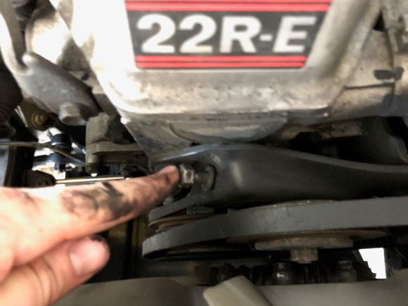 this is the tensioner bolt for the idler, run this bolt out after letting off on the nut on front of the pulley.   