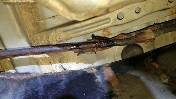 Old rusty pipe to the right side of Cat converter under passenger side