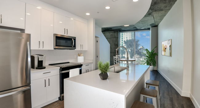 Kitchen with white cabinets, white quartz countertops, and stainless steel appliances